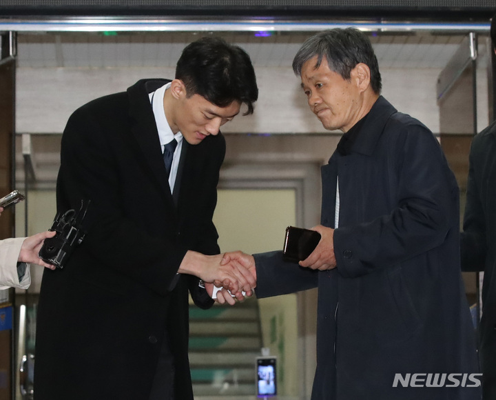 [서울=뉴시스] 조수정 기자 = 마약을 투약한 혐의로 경찰 조사를 마친 고(故) 전두환 전 대통령 손자 전우원 씨가 29일 오후 석방돼 서울 마포경찰서를 나서며 5·18 유족인 고(故) 전태일 열사 동생 전태삼 씨와 대화 나누며 악수하고 있다. 2023.03.29.chocrystal@newsis.com