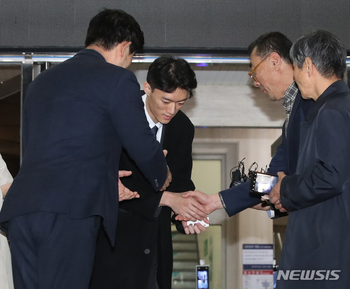 [서울=뉴시스] 조수정 기자 = 마약을 투약한 혐의로 경찰 조사를 마친 고(故) 전두환 전 대통령 손자 전우원 씨가 29일 오후 석방돼 서울 마포경찰서를 나서며 고(故)전태일 열사 동생 전태삼(오른쪽 앞) 씨, 이남(오른쪽 뒤) 5·18 민주화운동부상자회 서울지부장, 임장철(왼쪽 앞) 5·18민주화운동공로자회 서울지부장과 악수하고 있다. 2023.03.29.chocrystal@newsis.com