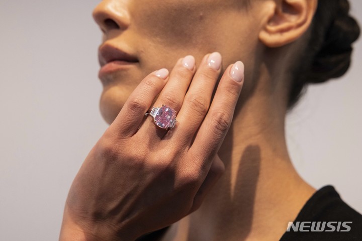 [뉴욕=AP/뉴시스] 지난 27일(현지시간) 미국 뉴욕의 소더비에서 이곳 관계자가 10.57캐럿짜리 핑크 다이아몬드 반지를 진열하고 있다. '이터널 핑크'(Eternal Pink)라는 이름의 이 다이아몬드는 6월 8일 소더비 경매에 나와 3500만 달러(한화 약 457억 원)에 낙찰될 것으로 예상된다. 2023.03.30.
