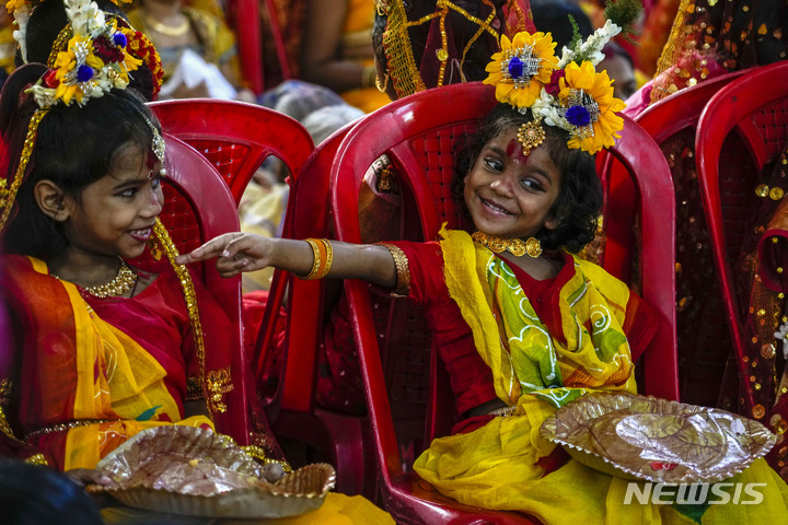 [콜카타=AP/뉴시스] 30일(현지시간) 인도 콜카타의 한 사원에서 힌두 축제 두르가 푸자 축제가 열려 살아있는 여신으로 분장한, 사춘기가 되지 않은 힌두교 소녀들이 축제 시작을 기다리고 있다. 이들은 '쿠마리' 또는 처녀신으로 숭배된다. 두르가 푸자는 '두르가 여신을 위한 의식'이란 의미로 두르가 여신이 악마 마히사수라에게 승리를 거둔 것을 기념하는 축제다. 2023.03.30.