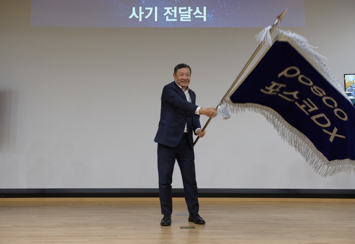 정덕균 포스코DX 사장이 비전선포식에서 직원대표들로부터 사기를 전달받아 힘차게 흔들고 있다(사진=포스코DX 제공) *재판매 및 DB 금지