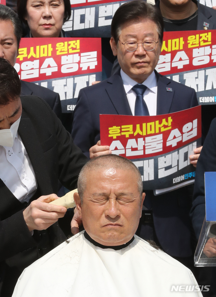 [서울=뉴시스] 전진환 기자 = 윤재갑 더불어민주당 의원이 30일 오전 서울 여의도 국회 본관 앞에서 열린 후쿠시마산 수산물 수입 반대 및 대일 굴욕외교 규탄대회에서 삭발을 하고 있다. 2023.03.30. amin2@newsis.com