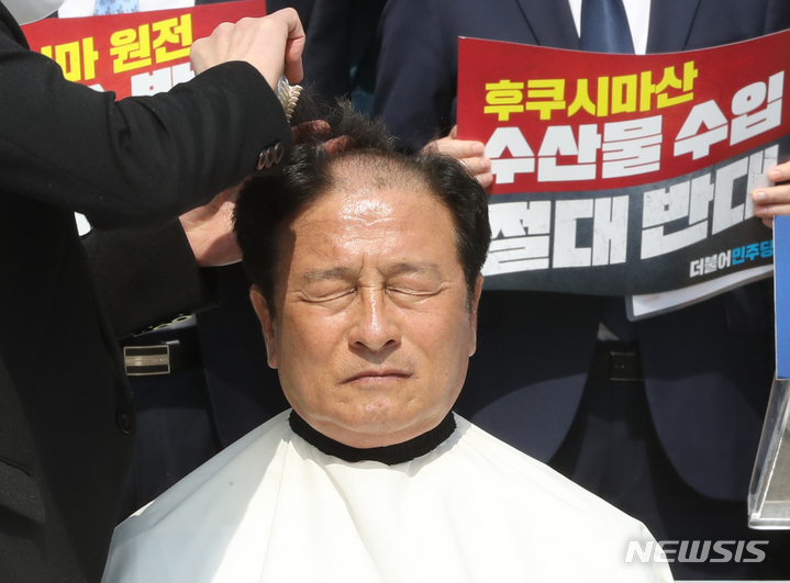 [서울=뉴시스] 전진환 기자 = 윤재갑 더불어민주당 의원이 30일 오전 서울 여의도 국회 본관 앞에서 열린 후쿠시마산 수산물 수입 반대 및 대일 굴욕외교 규탄대회에서 삭발을 하고 있다.&nbsp; 2023.03.30. amin2@newsis.com