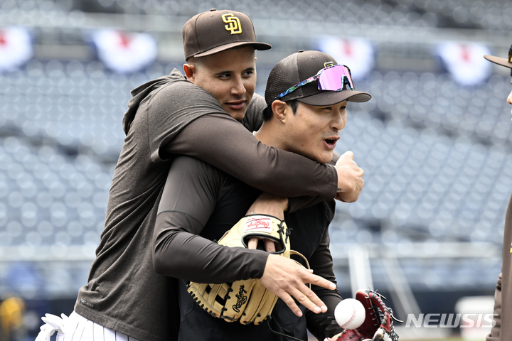 [샌디에이고=AP/뉴시스] 샌디에이고 파드리스 2루수 김하성(오른쪽)이 30일(현지시간) 미 캘리포니아주 샌디에이고의 펫코파크에서 열리는 2023 메이저리그(MLB) 콜로라도 로키스와의 개막전에 앞서 몸을 풀면서 3루수 매니 마차도 등 동료들과 얘기를 나누고 있다. 2023.03.31.