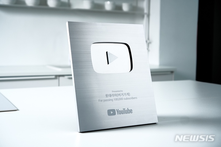 [서울=뉴시스]롯데GRS는 롯데리아의 공식 유튜브 채널 버거가게가 구독자 10만명을 달성, 실버 버튼 획득과 동시에 누적 조회수 1억뷰를 돌파했다.(사진=롯데리아 제공)