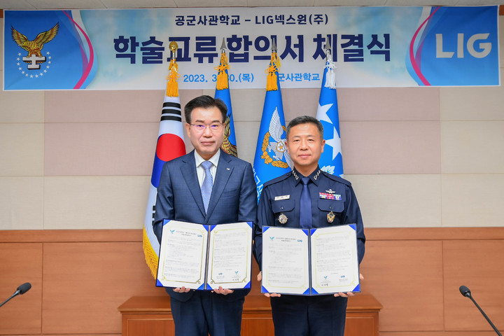 [서울=뉴시스] LIG넥스원 이건혁 PGM사업부문장(왼쪽)과 이상학 공군사관학교장(오른쪽)이 학술교류 합의서를 들고 기념 촬영을 하고 있다. (사진=LIG넥스원 제공) 2023.03.31. photo@newsis.com *재판매 및 DB 금지