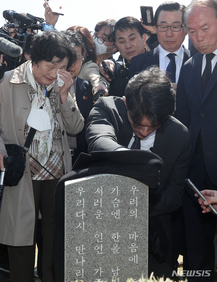 [광주=뉴시스] 김혜인 기자 = 고(故)  전두환씨의 손자인 전우원씨가 31일 오전 광주 북구 국립5 ·18민주묘지 내 문재학 열사의 묘소를 찾아 자신의 옷으로 묘비를 닦으며 넋을 위로하고 있다. 2023.03.31. hyein0342@newsis.com