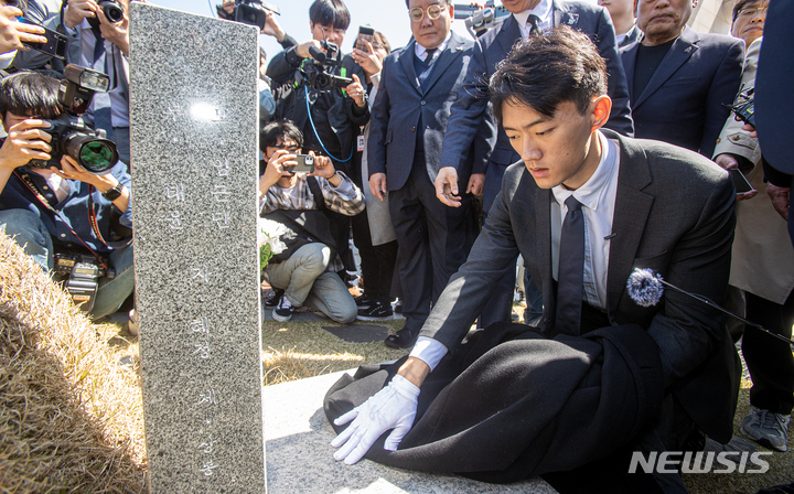 [광주=뉴시스] 김혜인 기자 = 고(故)  전두환씨의 손자인 전우원씨가 31일 오전 광주 북구 국립5 ·18민주묘지 내 김경철 열사의 묘소를 찾아 자신의 옷으로 묘비를 닦으며 넋을 위로하고 있다. 2023.03.31. hyein0342@newsis.com