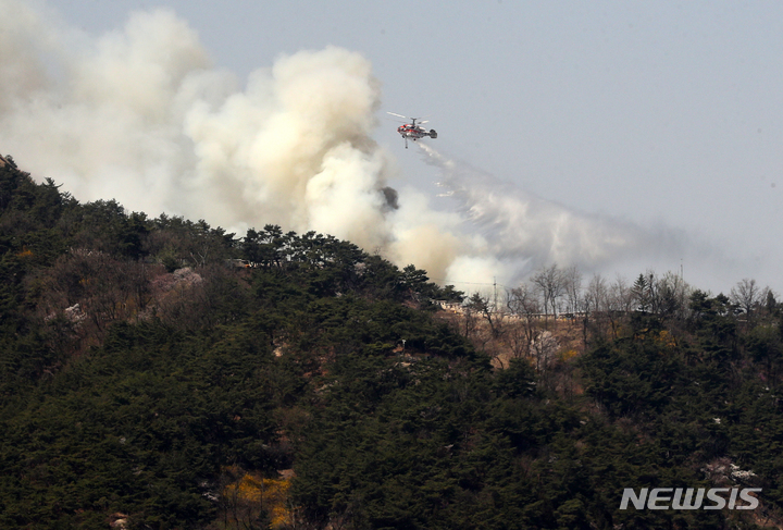 [서울=뉴시스] 배훈식 기자 = 소방헬기가 2일 오후 서울 종로구 인왕산에서 발생한 산불 진화를 하고 있다. 2023.04.02. dahora83@newsis.com