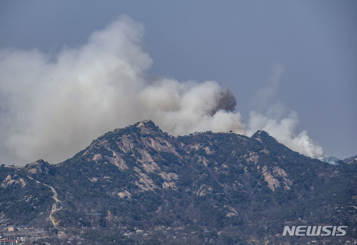 [서울=뉴시스] 정병혁 기자 = 2일 오전 11시 54분쯤 서울 종로구 인왕산에서 화재가 발생해 연기 피어오르고 있다. 소방당국은 장비 22대와 인력 69명을 투입해 진화 작업을 벌이고 있다. 2023.04.02. jhope@newsis.com
