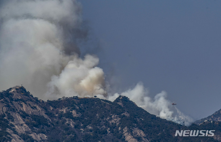 [서울=뉴시스] 정병혁 기자 = 2일 오전 11시 54분쯤 서울 종로구 인왕산에서 화재가 발생해 연기 피어오르고 있다. 소방당국은 장비 22대와 인력 69명을 투입해 진화 작업을 벌이고 있다. 2023.04.02. jhope@newsis.com