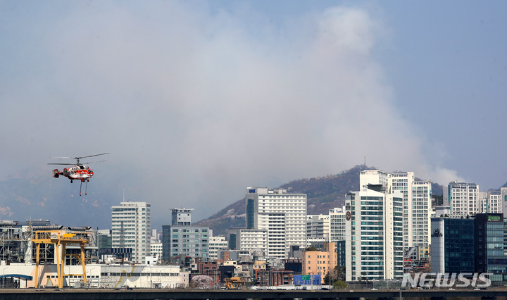 [서울=뉴시스] 추상철 기자 = 인왕산에 산불이 발생한 2일 오후 서울 영등포구 여의도 한강에서 산림청 헬기가 급수를 마친 후 화재진압을 위해 이동하고 있다. 2023.04.02. scchoo@newsis.com