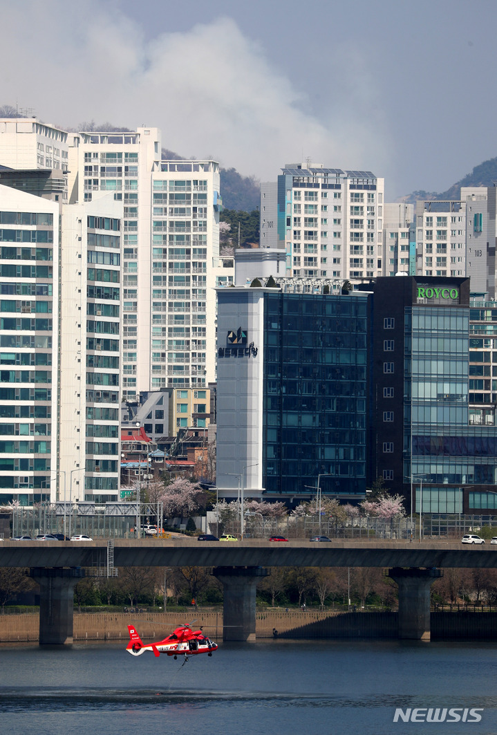 [서울=뉴시스] 추상철 기자 = 인왕산에 산불이 발생한 2일 오후 서울 영등포구 여의도 한강에서 소방헬기가 급수를 하고 있다. 2023.04.02. scchoo@newsis.com