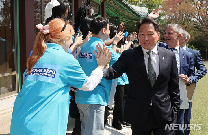 [서울=뉴시스] 김진아 기자 = 최태원 대한상공회의소 회장이 3일 오전 서울의 한 호텔에서 2030세계박람회 개최 후보지인 부산을 실사하기 위해 방한한 국제박람회기구(BIE) 실사단과 오찬 간담회를 위해 이동하며 부산엑스포 서포터즈들과 하이파이브를 하고 있다. (공동취재사진) 2023.04.03. bluesoda@newsis.com