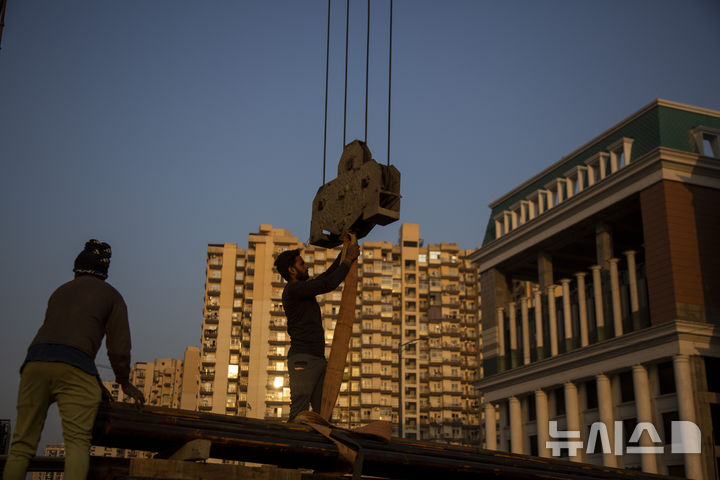 [그레이터노이다=AP/뉴시스]인도 그레이터노이다에서 건설 자재를 다루는 노동자들. 2024.09.25.