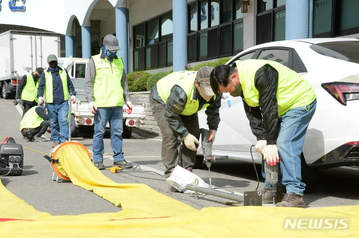 [청주=뉴시스] 임선우 기자 = 충북 청주지법 집행관실 관계자들이 4일 청주시청 신청사 부지를 무단 점유 중인 청주병원 측 주차장에 대한 부동산 인도 강제집행을 벌이고 있다. 2023.04.04. imgiza@newsis.com