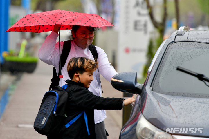 [광주=뉴시스] 이영주 기자 = 식목일을 하루 앞두고 비가 내리는 4일 오후 광주 서구 5·18기념문화센터 앞에서 아이들이 비를 피하기 위해 차량 문을 급히 열고 있다. 2023.04.04. leeyj2578@newsis.com