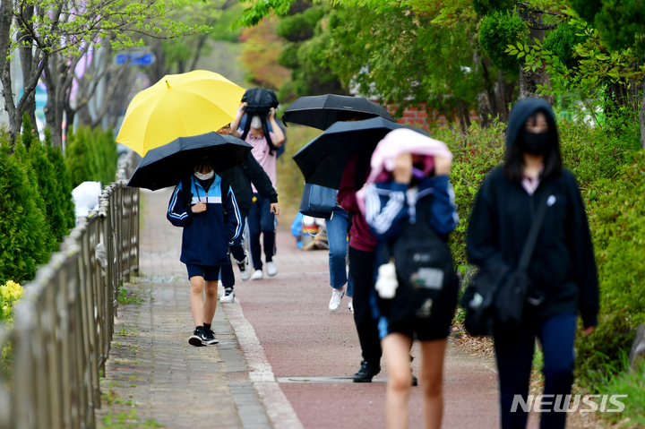 [광주=뉴시스] 이영주 기자 = 식목일을 하루 앞두고 비가 내리는 지난해 4월 4일 오후 광주 서구 5·18기념문화센터 앞에서 학생들이 하교하고 있다. 2023.04.04. leeyj2578@newsis.com