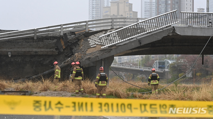 [성남=뉴시스] 김종택 기자 = 5일 오전 경기도 성남시 분당구 정자교 난간이 무너지는 사고가 발생해 소방 대원 등 관계자들이 현장을 수습하고 있다. 이 사고로 교각 가드레일과 이정표 등이 산책로로 쏟아져 30대 여성 1명이 숨지고 30대 남성 1명은 중상을 입어 병원에서 치료 중이다. 2023.04.05. jtk@newsis.com