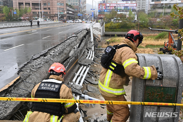 [성남=뉴시스] 김종택 기자 = 5일 오전 경기도 성남시 분당구 정자교 난간이 무너지는 사고가 발생해 소방 대원 등 관계자들이 현장을 수습하고 있다. 이 사고로 교각 가드레일과 이정표 등이 산책로로 쏟아져 30대 여성 1명이 숨지고 30대 남성 1명은 중상을 입어 병원에서 치료 중이다. 2023.04.05. jtk@newsis.com