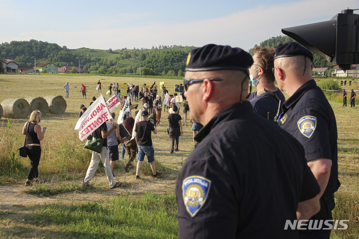 [ 자그레브( 크로아티아)=AP/뉴시스] 크로아티아 경찰들이 보스니아 헤르체고비나와의 국경지대에서 난민유입을 막는 정부 정책에 반대하는 시위대 행렬을 바라보고 있다.&nbsp; 2023년에도 인권단체들은 경찰이 중요한 이민루트에 관한 정보를 공개해 이민들을 위험에 빠뜨렸다며 시위에 나섰다.&nbsp; 