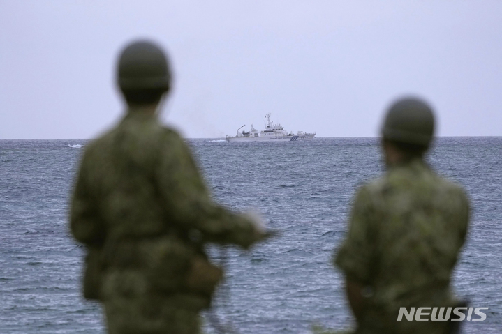 [미야코지마=AP/뉴시스]7일 일본 오키나와현 미야코지마 앞바다에서 해상보안청 선박이 실종된 육상자위대 헬기를 수색하고 있다. 이를 자위대 대원들이 지켜보고 있다. 2023.04.07