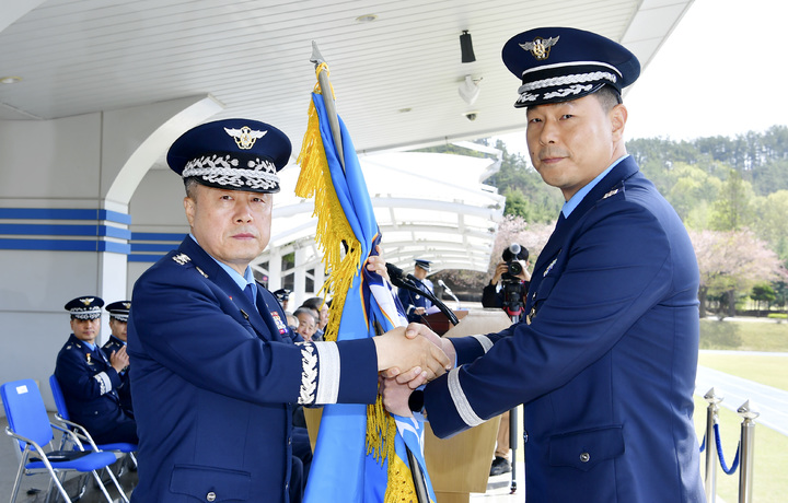 [진주=뉴시스] 교육사 창설50주년 및 항공우주통제학교 창설 기념행사 중 유재문 공군교육사령관(왼쪽)이 부대의 지휘를 상징하는 부대기를 초대 항공우주통제학교장 김시몬 대령(오른쪽)에게 전달하고 있다. *재판매 및 DB 금지