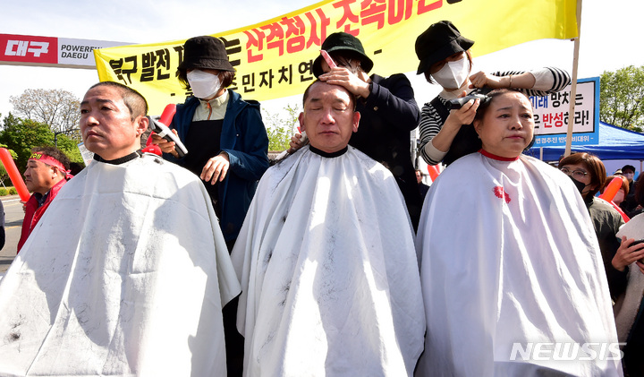 [대구=뉴시스] 이무열 기자 = 10일 오전 대구시청 산격청사 앞에서 열린 '문화예술허브 달성군 변경 추진 즉각 철회' 발대식에서 김진석 산격1동 주민자치위원회 운영위원, 이성장(가운데) 북구 주민자치위원장, 윤숙미 침산1동 주민자치위원장이 삭발을 하고 있다. 2023.04.10. lmy@newsis.com