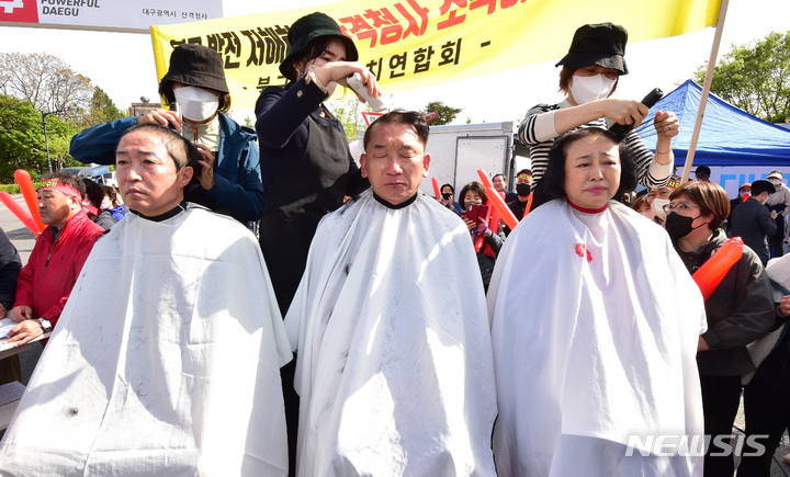 [대구=뉴시스] 이무열 기자 = 10일 오전 대구시청 산격청사 앞에서 열린 '문화예술허브 달성군 변경 추진 즉각 철회' 발대식에서 김진석 산격1동 주민자치위원회 운영위원, 이성장(가운데) 북구 주민자치위원장, 윤숙미 침산1동 주민자치위원장이 삭발을 하고 있다. 2023.04.10. lmy@newsis.com