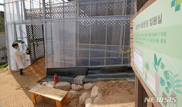 [서울=뉴시스] 조성우 기자 = 10일 오후 서울 서초구 농업기술센터에 개원한 반려식물병원에서 식물의사가 식물을 입원실로 옮기고 있다. 2023.04.10. xconfind@newsis.com