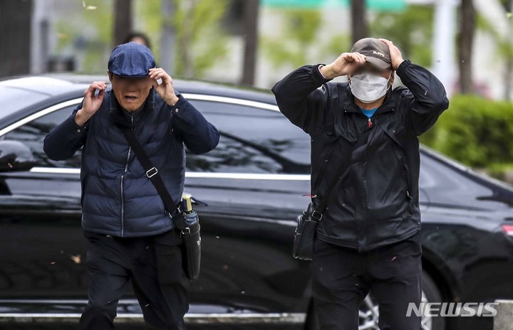 [서울=뉴시스] 정병혁 기자 = 수도권 등 전국 대부분 지역에 강풍특보가 내린 11일 오전 서울 강남구 서울본부세관 인근 인도에서 한 시민이 모자를 잡은 채 이동하고 있다. 2023.04.11. jhope@newsis.com