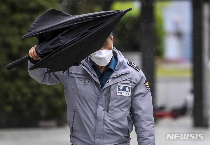 [서울=뉴시스] 정병혁 기자 = 수도권 등 전국 대부분 지역에 강풍특보가 내린 11일 오전 서울 강남구 서울본부세관 인근 인도에서 한 시민이 우산으로 바람을 막으며 이동하고 있다. 2023.04.11. jhope@newsis.com