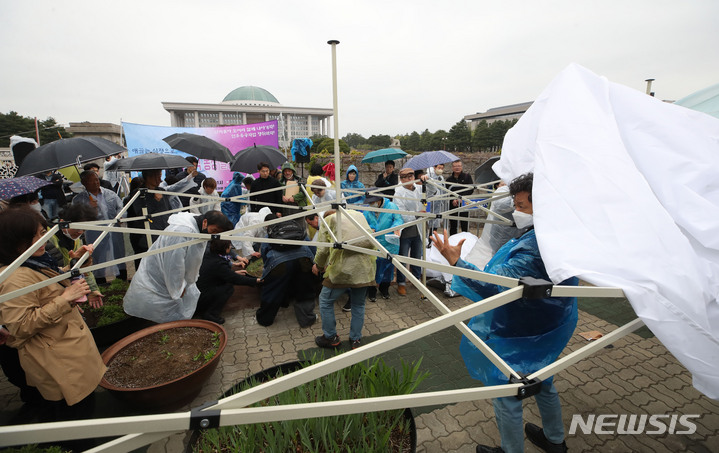 [서울=뉴시스] 조수정 기자 = 11일 서울 영등포구 국회 앞에서 열린 민주유공자법 제정 촉구 및 전국민주유가족협의회 부모님 단식농성 돌입 기자회견이 끝난 뒤 관계자들이 농성 천막을 설치하고 있다. 2023.04.11.chocrystal@newsis.com