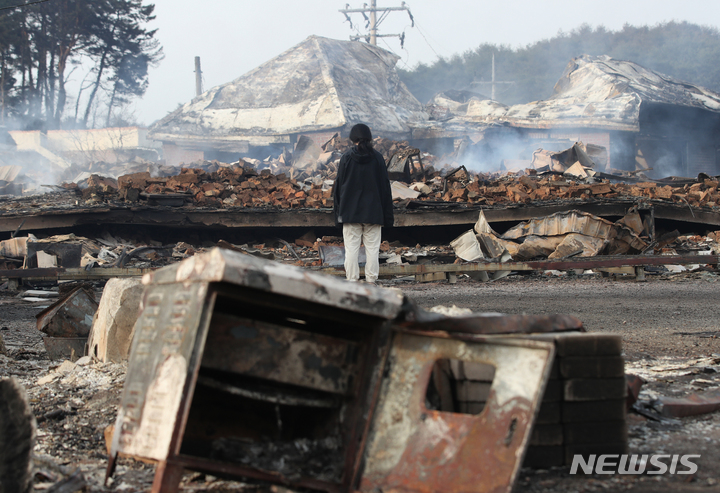 [강릉=뉴시스] 고승민 기자 = 전날인 11일 강원 강릉 난곡동 야산에서 발생한 산불로 바람에 옮겨 붙어 전소된 안현동의 한 민가와 펜션을 찾은 주민이 슬픔에 잠겨 있다. 2023.04.11. kkssmm99@newsis.com