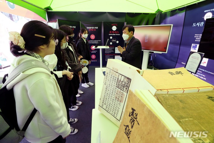 [서울=뉴시스] 조성봉 기자 = ‘도서관의 날’을 맞아 12일 오후 서울 종로구 광화문 광장에서 열린 도서관 캠프에서 국립중앙도서관 관계자가 '동의보감', '경국대전' 등 고서들을 학생들에게 설명하고 있다. 2023.04.12. suncho21@newsis.com