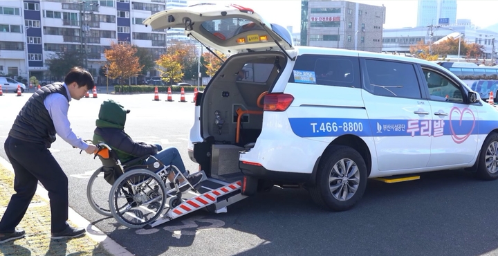 [부산=뉴시스] 두리발 복지매니저가 휠체어 교통약자를 차량에 탑승시키고 있다. (사진=부산시설공단 제공) *재판매 및 DB 금지
