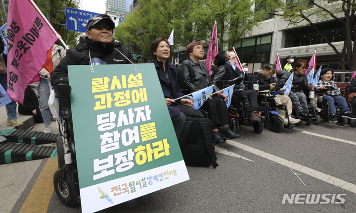 [서울=뉴시스] 최진석 기자 = 김진수(앞줄 왼쪽) 전국탈시설장애인연대 공동준비위원장이 지난해 4월13일 서울 중구 서울시청 인근에서 열린 '전국탈시설장애인연대 창립대회'에서 탈시설을 촉구하는 피켓을 들고 있다. 2023.04.13. myjs@newsis.com