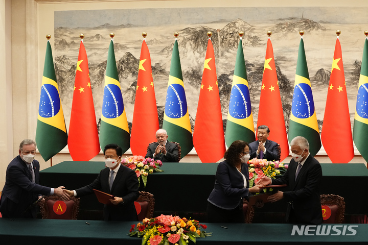 [베이징=AP/뉴시스] 중국과 브라질이 14일 열린 정상회담을 계기로 양국 재무부간 양해각서를 체결하고 자국 통화(중국 위안과 브라질 헤알)를 활용한 무역을 강화하기로 합의했다. 사진은 시진핑 중국 국가주석과 루이스 이나시오 룰라 다시우바 브라질 대통령이 지켜보는 가운데 양국 관계자가 합의를 체결하는 모습. 2023.04.16 