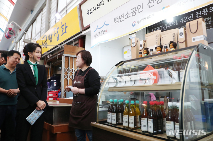 [대전=뉴시스] 홍효식 기자 = 윤석열 대통령 부인 김건희 여사가 14일 오후 대전 중구 태평전통시장을 방문해 참기름을 구매하고 있다. 2023.04.14. yesphoto@newsis.com