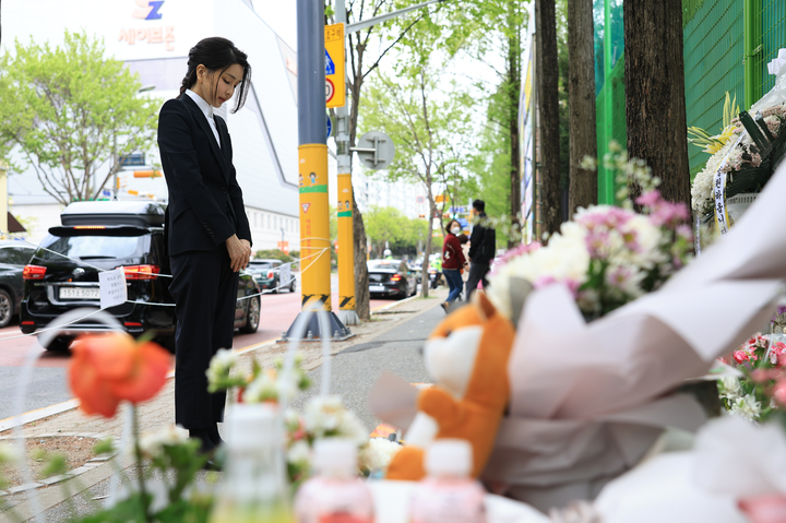[대전=뉴시스] 윤석열 대통령 부인 김건희 여사가 14일 대전 서구 둔산동 어린이보호구역에서 음주 교통사고로 숨진 고(故) 배승아 어린이의 사고 현장을 찾아 추모하고 있다. (사진=대통령실 제공) 2023.04.14. photo@newsis.com *재판매 및 DB 금지