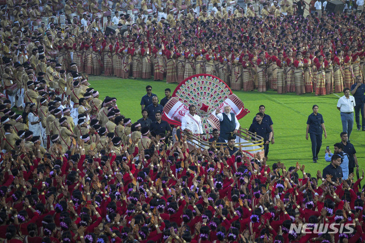 [구와하티=AP/뉴시스] 나렌드라 모디 인도 총리가 14일(현지시간) 아삼주 구와하티에서 열린 세계 최다 인원 민속 무용 공연 부문 기네스 기록 도전 현장에 참석해 대기 중인 무용수와 음악가들을 응원하고 있다. 이날 약 1만1천 명의 비후 댄서와 음악가가 공연을 함께하며 기네스 세계 기록을 세웠다. 2023.04.15.