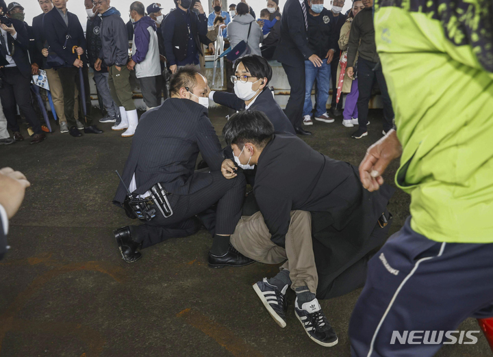 [와카야마=AP/뉴시스]15일 일본 서부 와카야마현의 한 항구에서 연막탄으로 보이는 것을 던진 한 남성이 땅에 쓰러져 있다. 기시다 후미오 총리는 현장에서 대피했고 인명피해는 발생하지 않았다. 2023.04.15.