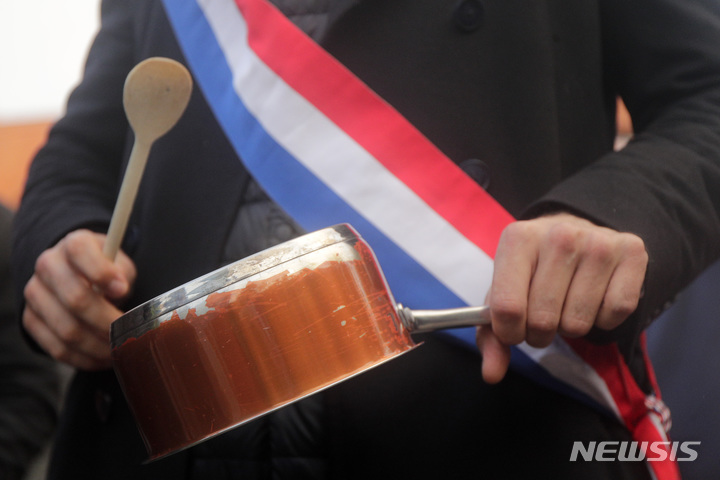 [릴=AP/뉴시스] 에마뉘엘 마크롱 프랑스 대통령이 17일(현지시간) 연금 개혁과 관련해 TV 대국민 연설을 하는 동안 릴에서 시위대가 냄비를 두드리고 있다. 마크롱 대통령은 정년을 62세에서 64세로 올린 데 대한 국민의 분노를 들었다면서도 이는 필요한 개혁이었다고 말했다. 이에 프랑스 8개 주요 노조는 "대통령이 여전히 국민의 분노를 이해하지 못하고 있다"라며 "5월 1일 프랑스 전역에서 국민의 진짜 분노를 들려주겠다"라고 경고했다. 2023.04.18.