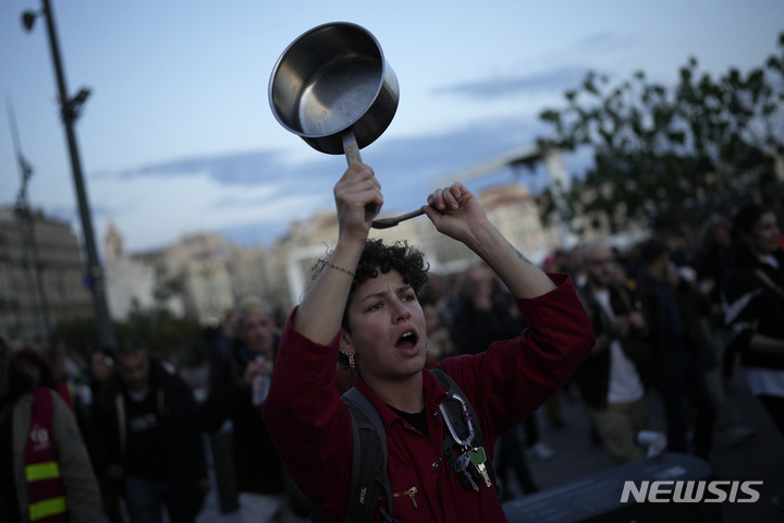 [마르세유=AP/뉴시스] 에마뉘엘 마크롱 프랑스 대통령이 17일(현지시간) 연금 개혁과 관련해 TV 대국민 연설을 하는 동안 마르세유에서 시위대가 냄비를 두드리고 있다. 마크롱 대통령은 정년을 62세에서 64세로 올린 데 대한 국민의 분노를 들었다면서도 이는 필요한 개혁이었다고 말했다. 이에 프랑스 8개 주요 노조는 "대통령이 여전히 국민의 분노를 이해하지 못하고 있다"라며 "5월 1일 프랑스 전역에서 국민의 진짜 분노를 들려주겠다"라고 경고했다. 2023.04.18.