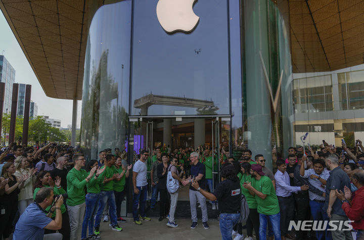 [뭄바이=AP/뉴시스]지난 4월18일(현지시간) 인도 뭄바이에서 열린 애플의 첫 번째 플래그십스토어 개소식에서 팀 쿡 애플 최고경영자가 방문객을 맞이하고 있다. 애플은 인도에서 첫 번째 플래그십스토어를 열었는데, 이는 인도 국내에서 사업을 확장하려는 애플의 열망을 강조하는 한편, 잠재적인 제조 중심지가 되기를 바라는 애플의 희망을 반영한다. 2023.12.06.