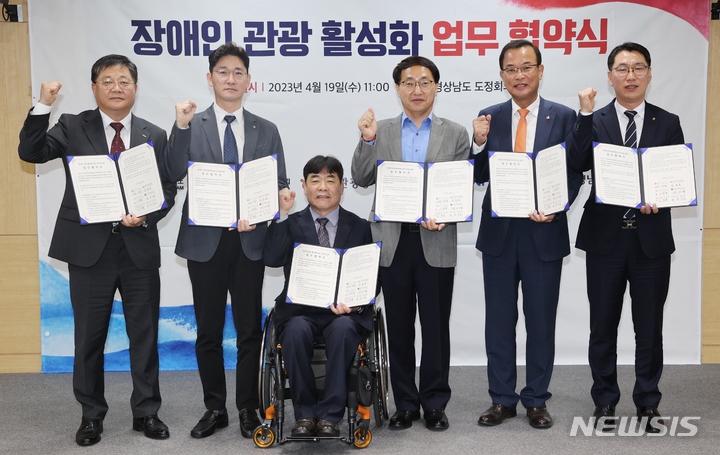 [창원=뉴시스] 홍정명 기자=19일 경남도청 도정회의실에서 박상호(왼쪽부터) BNK경남은행 여신영업본부장, 김동규 NH농협은행 경남영업부장, 강용순 경남장애인단체총연합회장, 최만림 경남도 행정부지사, 강기철 경상남도사회복지공동모금회장, 이국희 한국관광공사 경남지사장이 '장애인 관광 활성화를 위한 업무협약'을 체결하고 있다.(사진=경남도 제공) 2023.04.19. photo@newsis.com