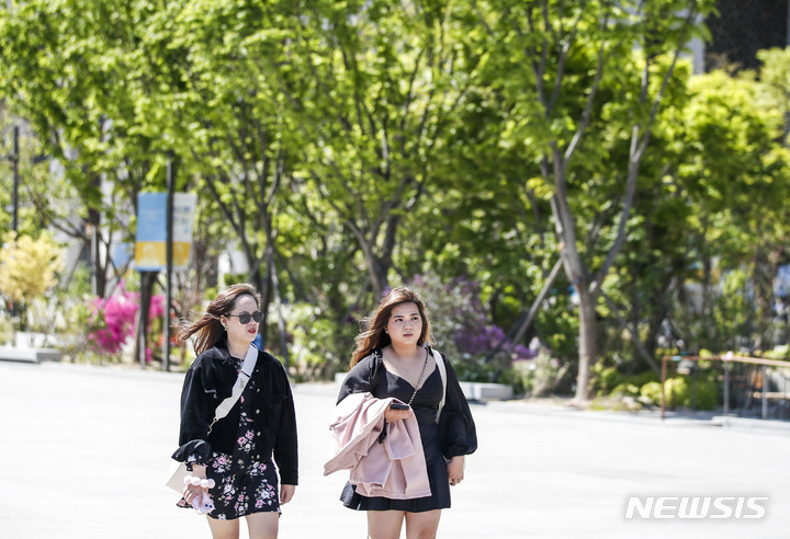 [서울=뉴시스] 정병혁 기자 = 서울 낮 최고기온이 27도까지 오를 것으로 예보된 19일 서울 종로구 광화문광장에서 짧은 옷차림을 한 여행객들이 이동하고 있다. 2023.04.19. jhope@newsis.com