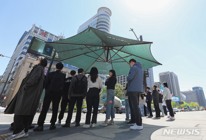 [서울=뉴시스] 권창회 기자 = 19일 오후 서울 종로구 광화문광장에서 시민들이 햇빛을 피해 그늘막 아래 모여있다. 2023.04.19. kch0523@newsis.com