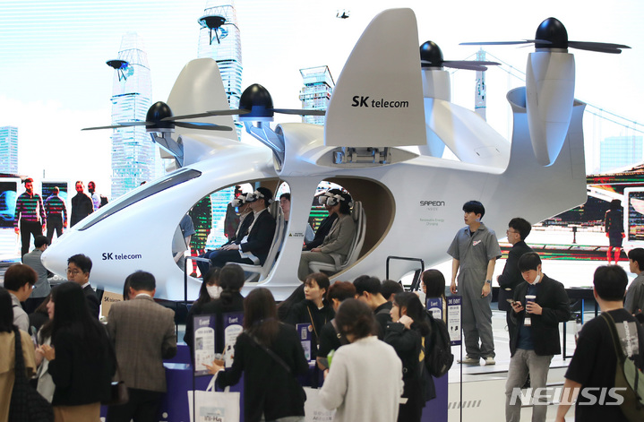 [서울=뉴시스] 김진아 기자 = 19일 오전 서울 강남구 코엑스에서 열린 '2023 월드IT쇼'를 찾은 관람객들이 SK텔레콤의 UAM을 체험하고 있다. 월드IT쇼는 국내 최대 규모의 ICT분야 전시로, 국내외 최신 ICT 트렌드 및 기술 산업 동향과 전망을 확인할 수 있다. 2023.04.19. bluesoda@newsis.com