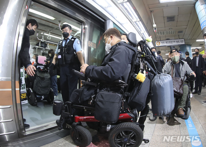 [서울=뉴시스] 김근수 기자 = 전국장애인차별철폐연대 회원들이 20일 서울 용산구 지하철 6호선 삼각지역에서 지하철에 탑승하고 있다. 2023.04.20. ks@newsis.com